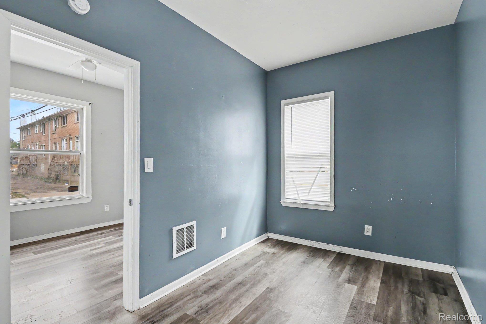 7743 Pitt Street Detroit, MI 48209 - Photo 13 of 15 Room featuring a window with blinds, light blue walls, and wood-finish flooring