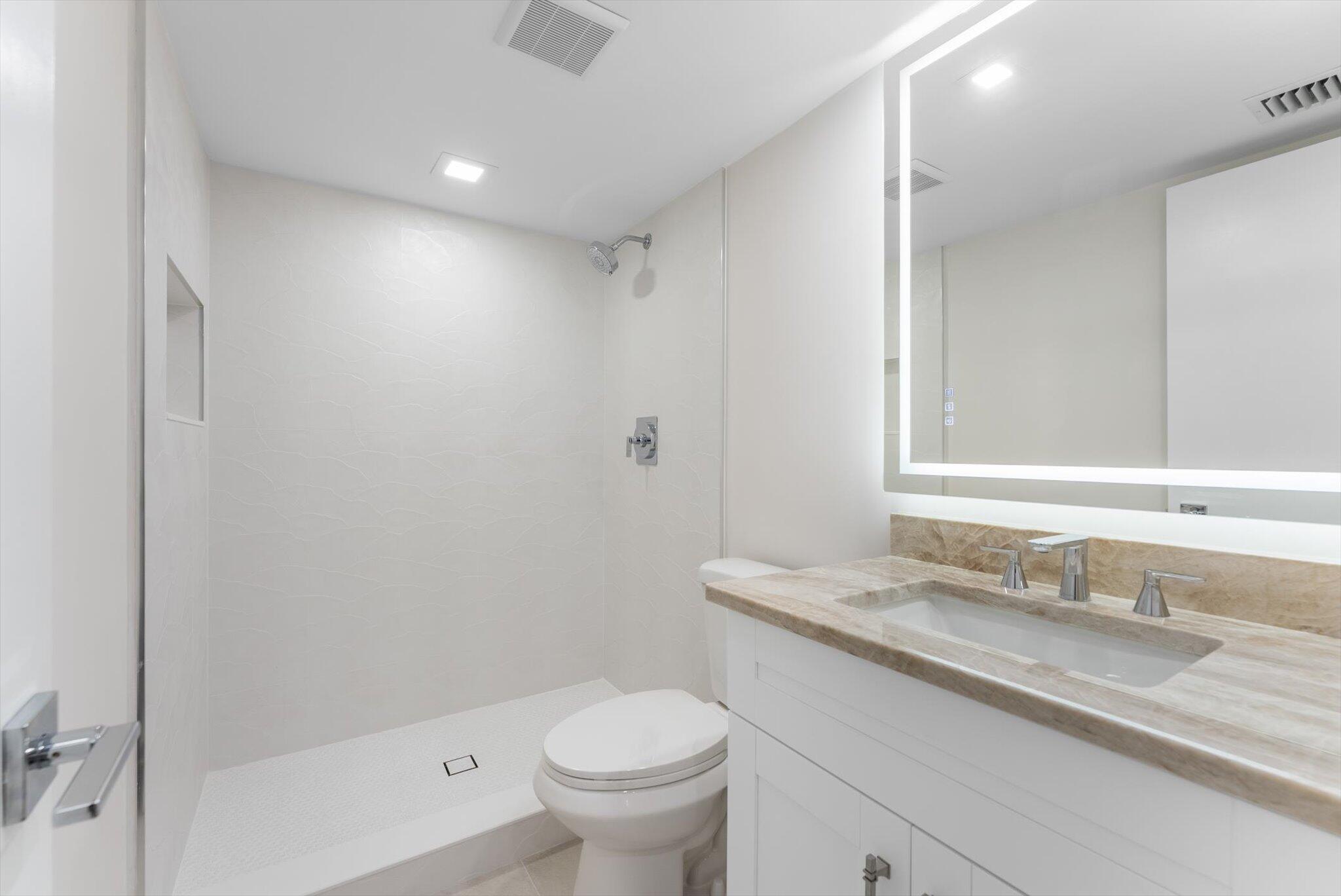 6562 Boca Del Mar Drive, Unit 222 Boca Raton, FL 33433 - Photo 17 of 39 a bathroom with a granite countertop sink a toilet and shower