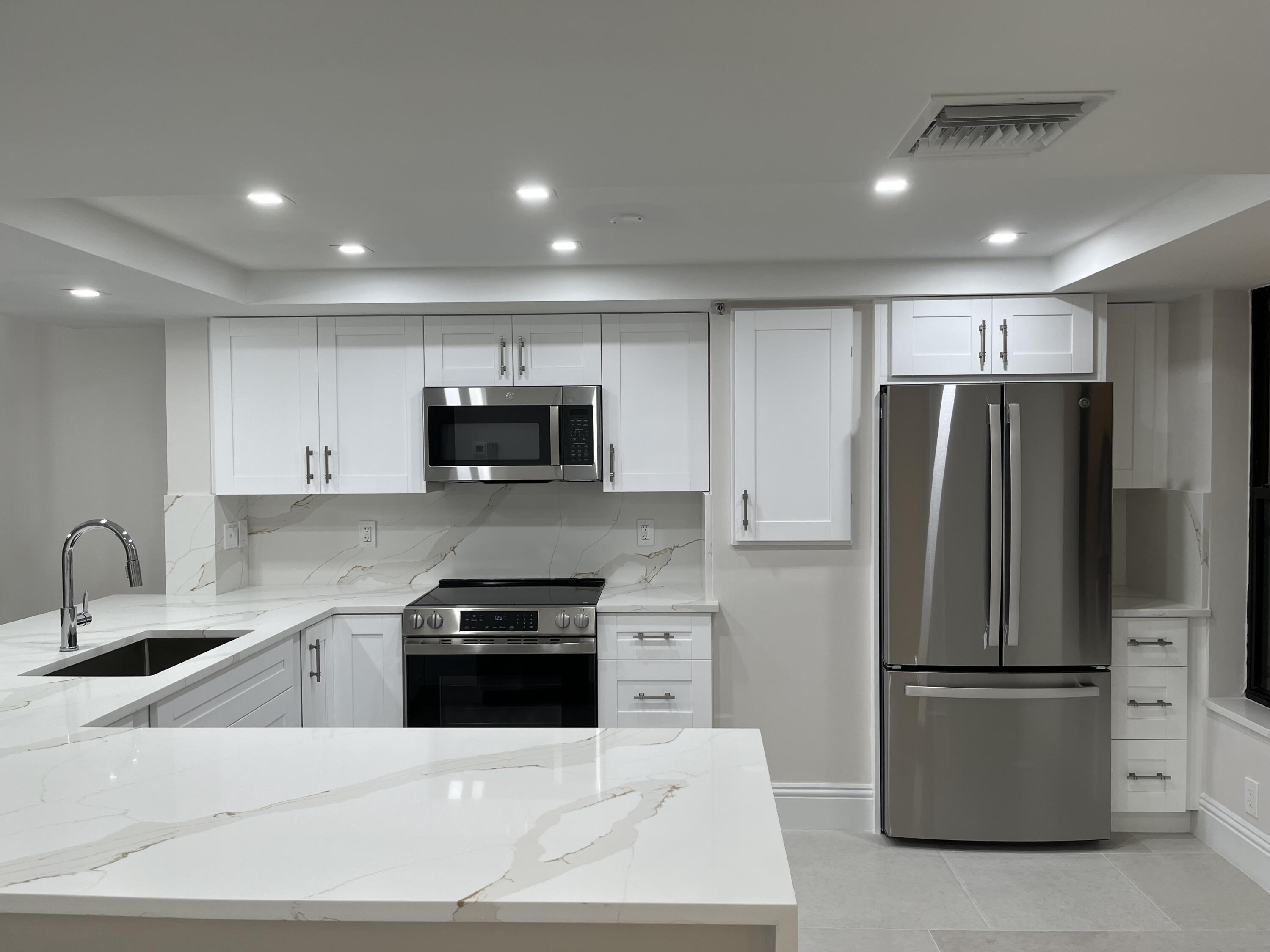 6562 Boca Del Mar Drive, Unit 222 Boca Raton, FL 33433 - Photo 2 of 39 a kitchen with stainless steel appliances a refrigerator a sink a stove a microwave and cabinets