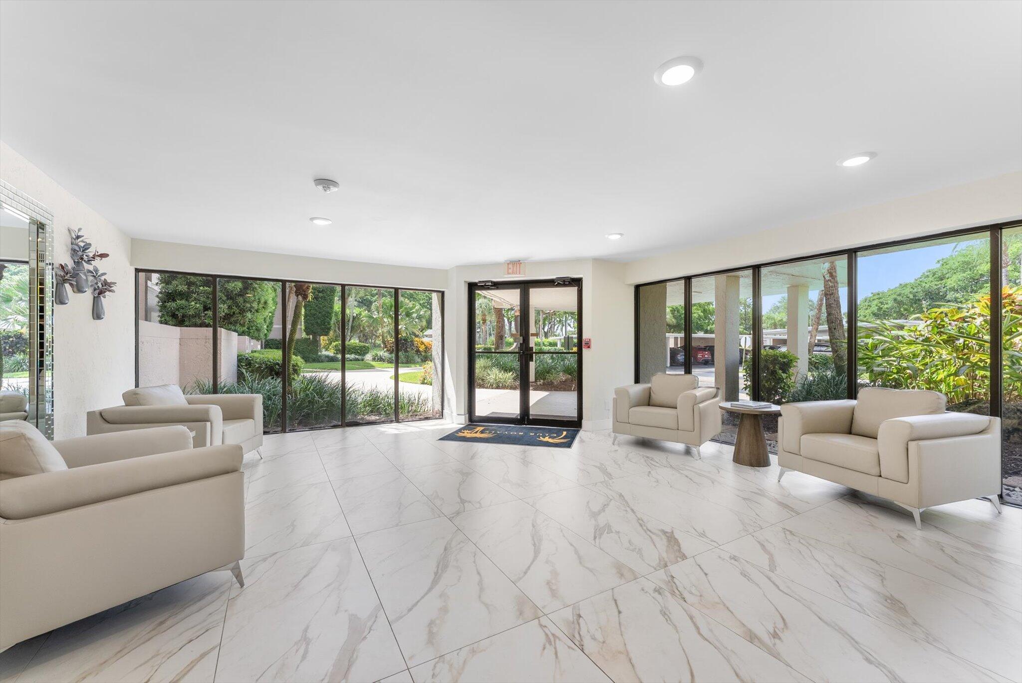 6562 Boca Del Mar Drive, Unit 222 Boca Raton, FL 33433 - Photo 23 of 39 a living room with furniture large windows and wooden floor
