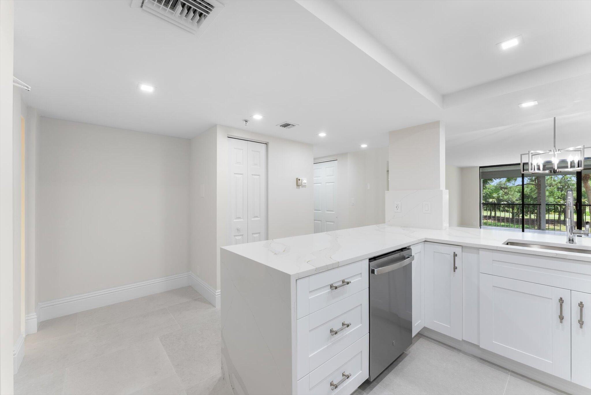 6562 Boca Del Mar Drive, Unit 222 Boca Raton, FL 33433 - Photo 6 of 39 a kitchen with white cabinets and sink