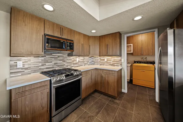 a kitchen with cabinets stainless steel appliances and sink
