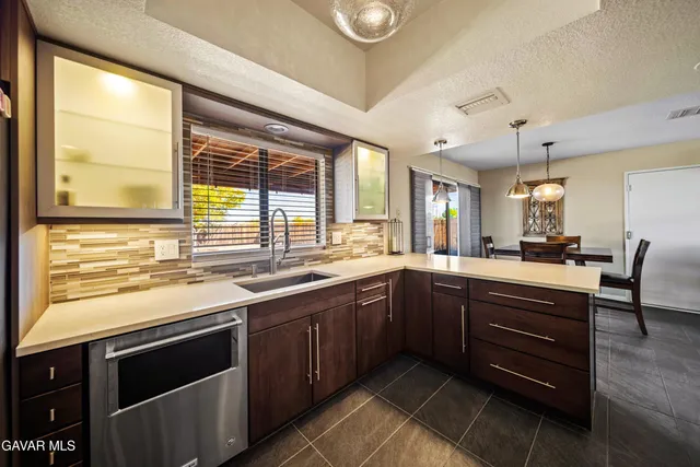a kitchen with stainless steel appliances granite countertop wooden cabinets a sink and a large window