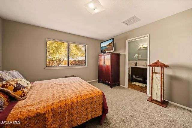 a bedroom with a bed and a refrigerator