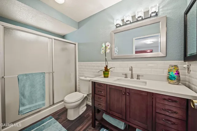 a bathroom with a toilet a sink and a mirror