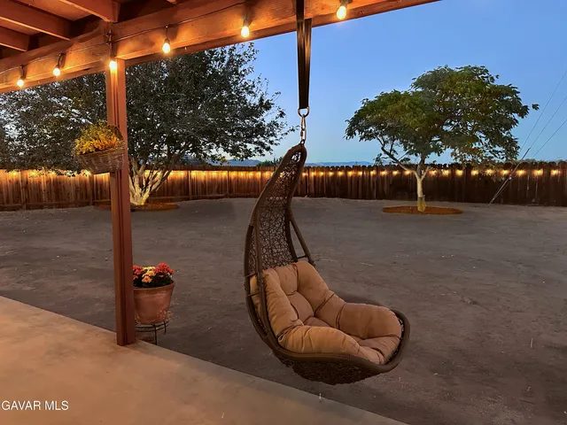 a backyard of a house with table and chairs