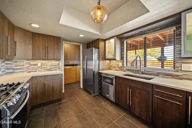 a kitchen with stainless steel appliances granite countertop a stove sink and cabinets