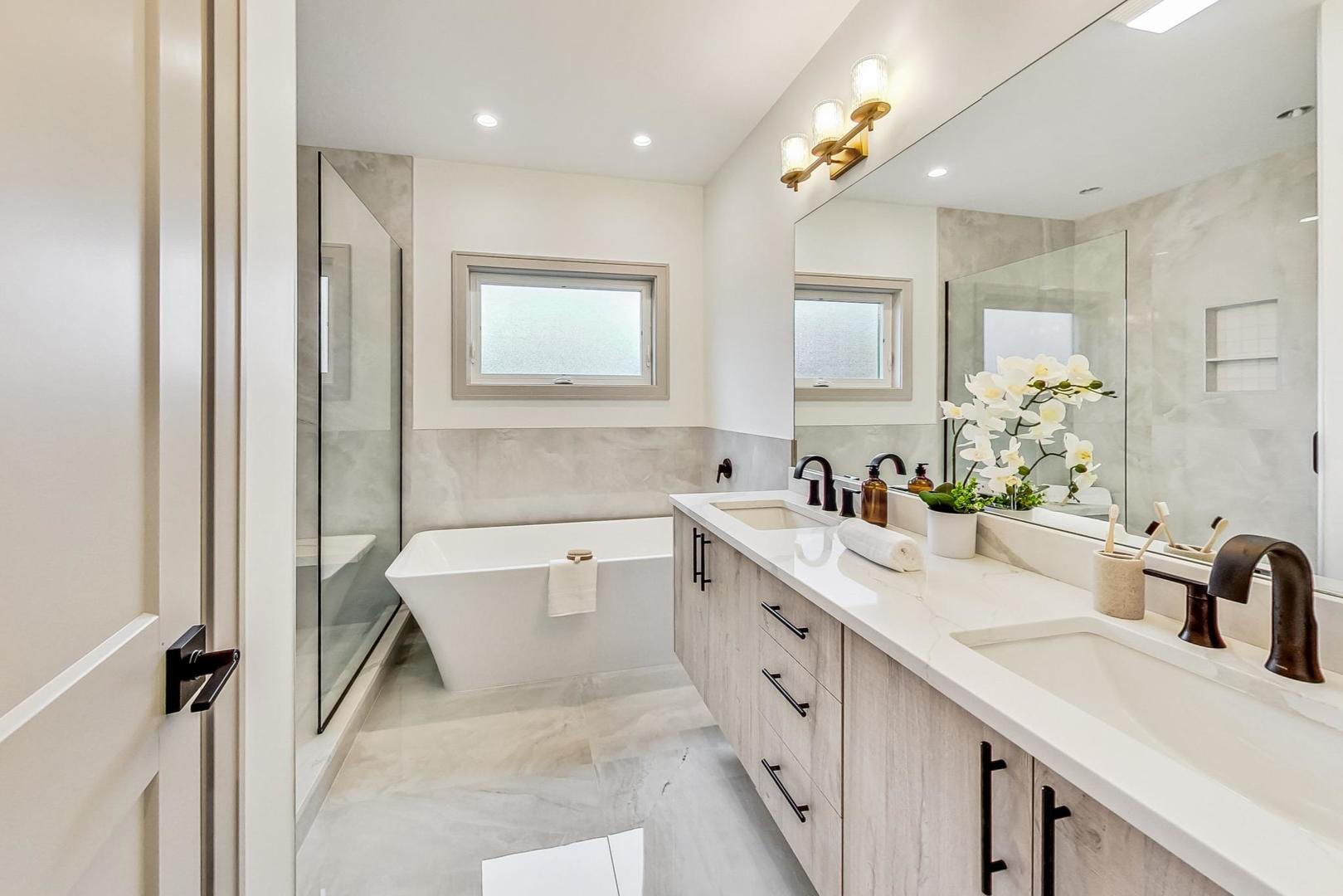 4244 South Champlain Avenue Chicago, IL 60653 - Photo 16 of 34 a spacious bathroom with a double vanity sink a mirror and a bathtub