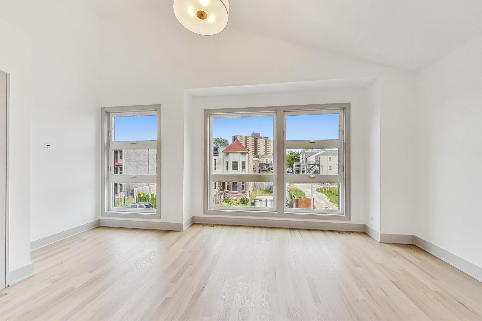 4244 South Champlain Avenue Chicago, IL 60653 - Photo 21 of 34 an empty room with window and wooden floor