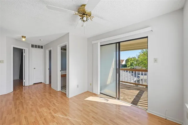 a view of a room with wooden floor and a ceiling fan
