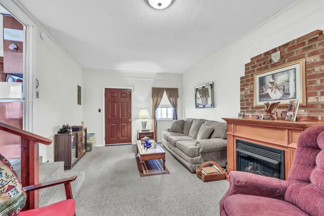 a living room with furniture a fireplace and a large window