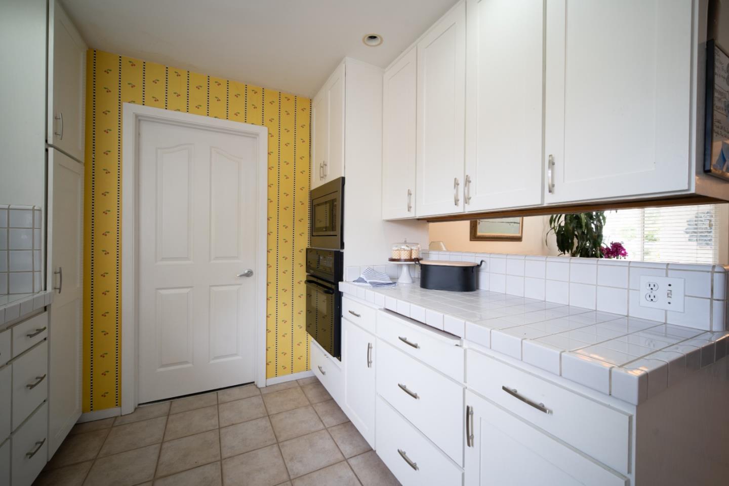 3445 Rio Road Carmel, CA 93923 - Photo 8 of 16 a kitchen with white cabinets and refrigerator