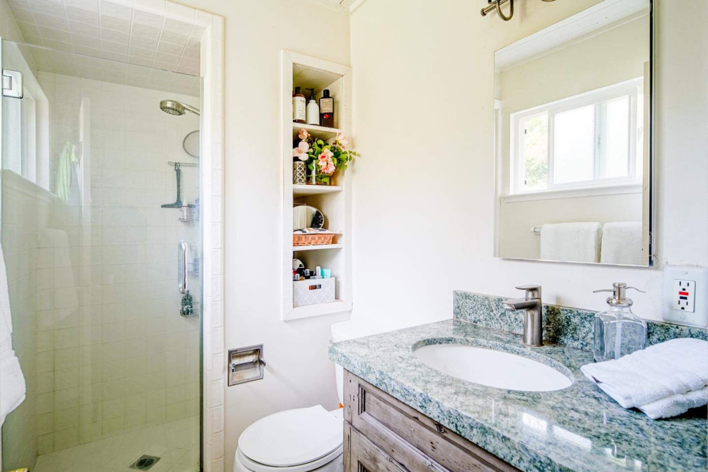3445 Rio Road Carmel, CA 93923 - Photo 9 of 16 a bathroom with a granite countertop sink and a mirror