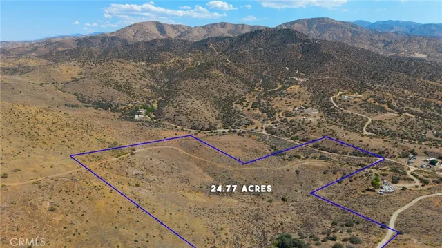 a view of a dry yard with mountains in the background