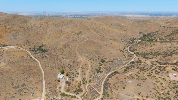a view of a dry yard with mountain in the background