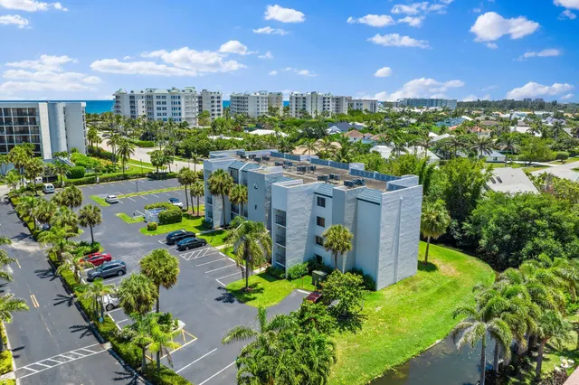a view of a building with a yard and palm trees
