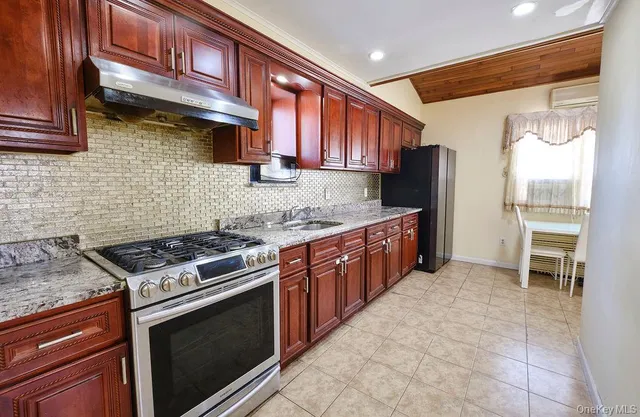a kitchen with stainless steel appliances granite countertop a stove a sink and a refrigerator