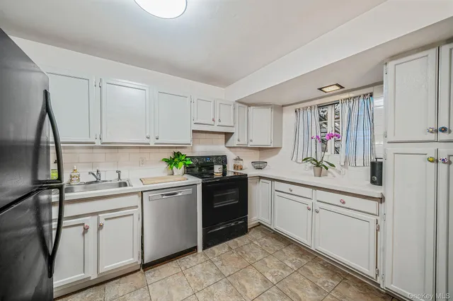 a kitchen with white cabinets and white appliances