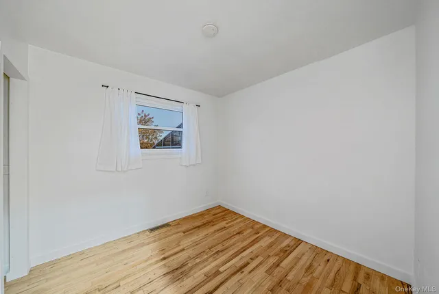 a view of a room with wooden floor and white walls