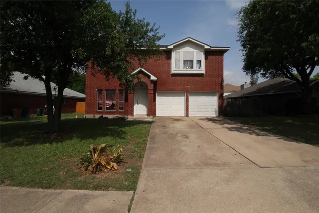 a front view of a house with a yard and a garage