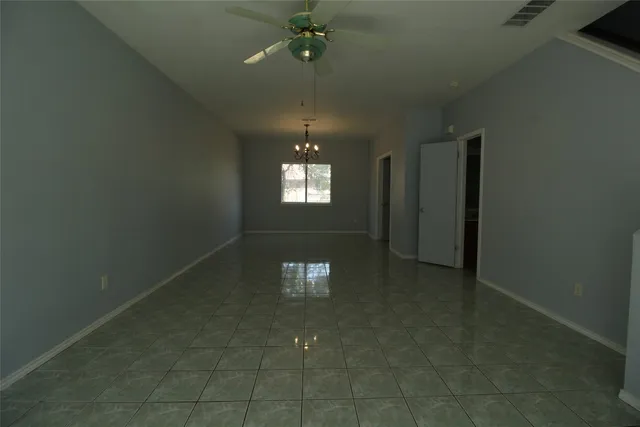 en empty room with windows and ceiling fan