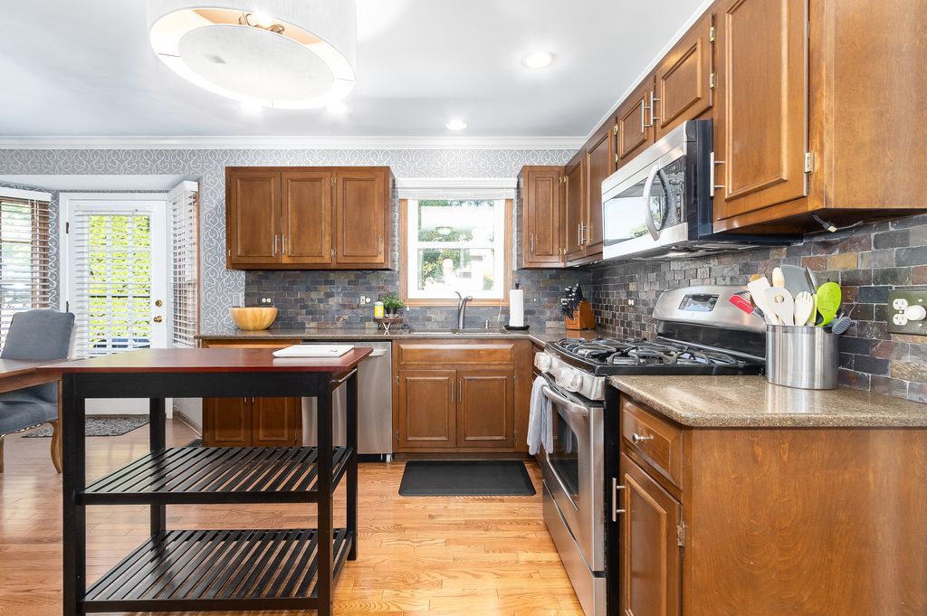 1712 Mundelein Road Naperville, IL 60565 - Photo 6 of 42 a kitchen with granite countertop a stove sink and cabinets