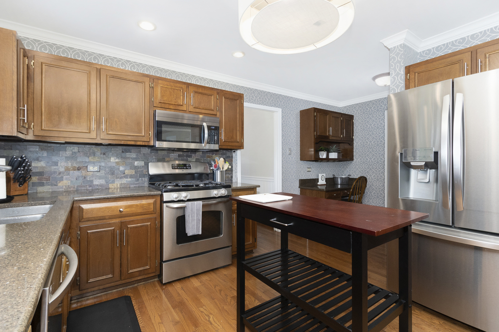 1712 Mundelein Road Naperville, IL 60565 - Photo 7 of 42 a kitchen with stainless steel appliances granite countertop a stove refrigerator sink and microwave