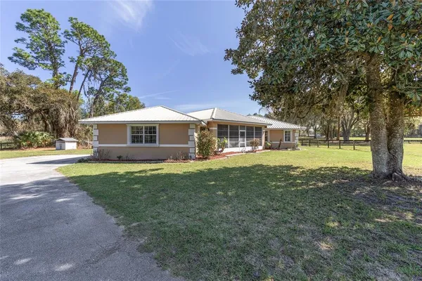 a view of a house with pool and a yard
