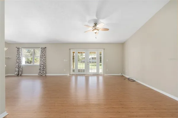a view of a room with wooden floor fireplace and windows