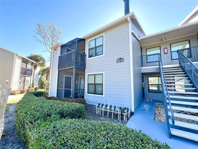 a view of a house with wooden deck and furniture
