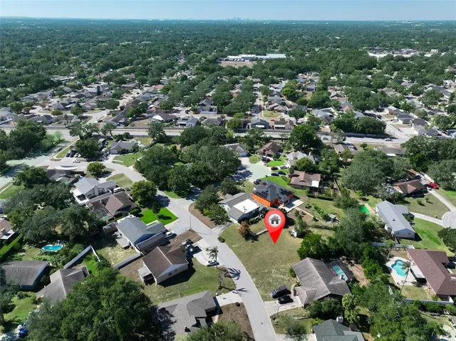 an aerial view of residential houses with outdoor space and trees