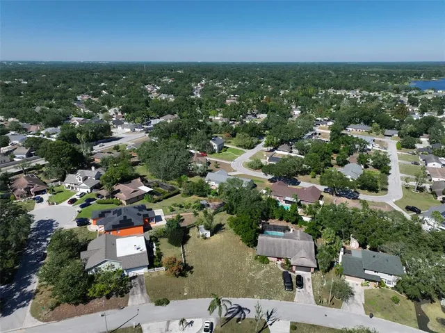 an aerial view of residential houses with outdoor space and trees