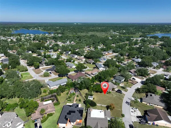 an aerial view of residential houses with outdoor space and trees