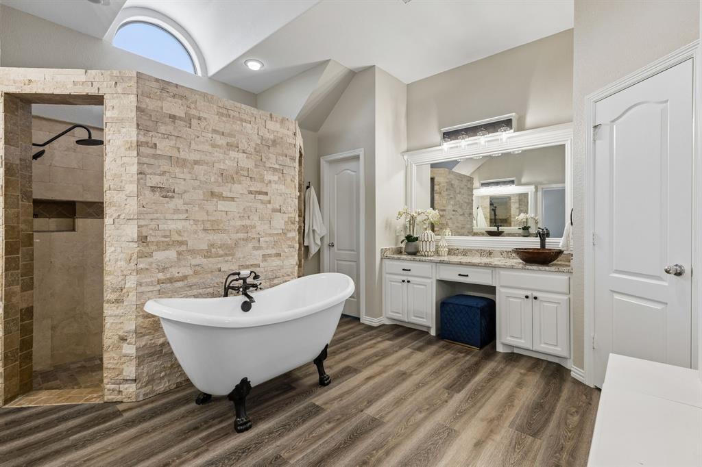 317 Singing Quail Trail Haslet, TX 76052 - Photo 15 of 32 Spacious bathroom featuring a freestanding clawfoot tub, a walk-in shower with tiled walls, and a double vanity with a vessel sink
