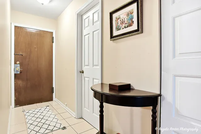 a view of a hallway with wooden floor and a bathroom