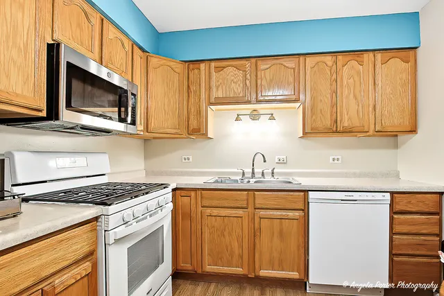 a kitchen with stainless steel appliances granite countertop a stove a sink and a microwave