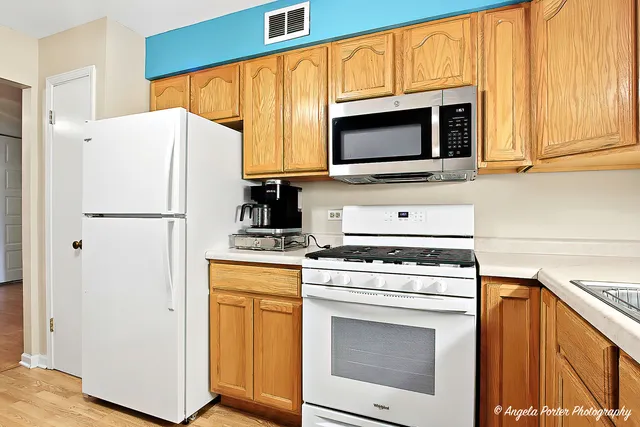 a kitchen with stainless steel appliances a stove microwave and refrigerator