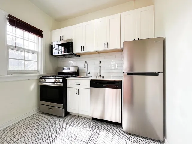 a kitchen with stainless steel appliances a refrigerator sink and microwave
