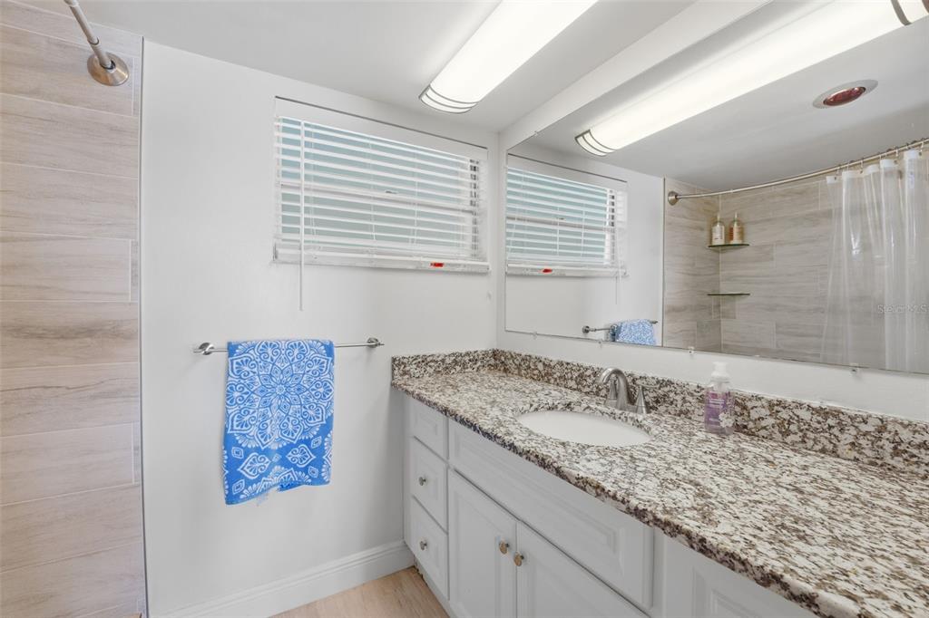 4440 Exeter Drive, Unit 106 Longboat Key, FL 34228 - Photo 14 of 26 a bathroom with a granite countertop sink and a bathtub