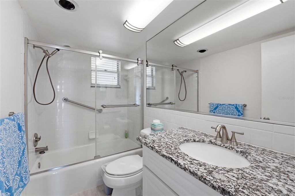4440 Exeter Drive, Unit 106 Longboat Key, FL 34228 - Photo 15 of 26 a bathroom with a granite countertop sink toilet and shower