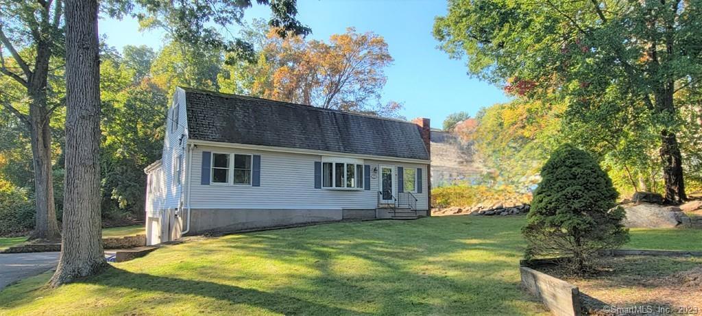 a view of house with backyard outdoor seating and trees
