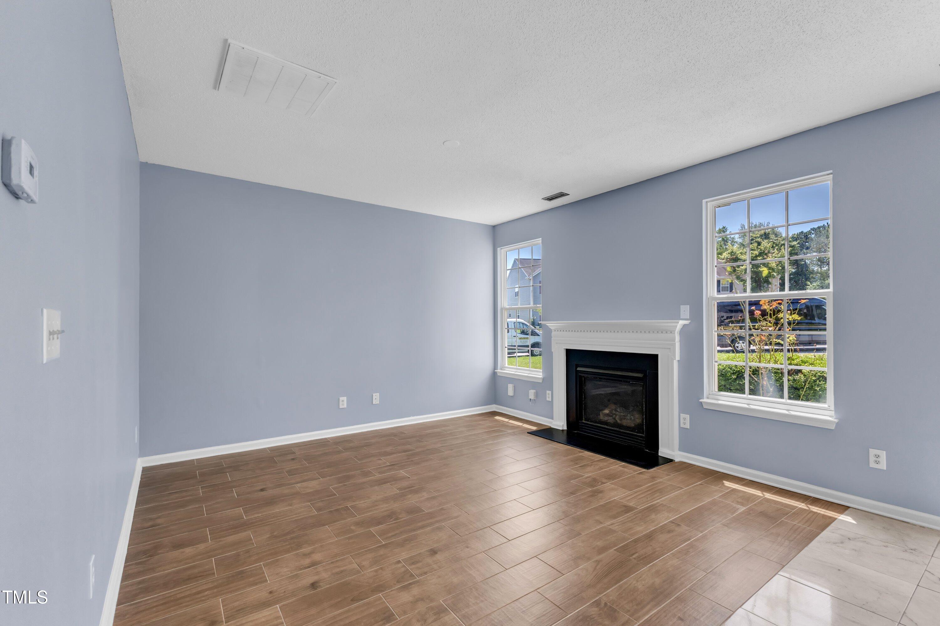 3604 Rivermist Drive Raleigh, NC 27610 - Photo 12 of 48 an empty room with windows and fireplace