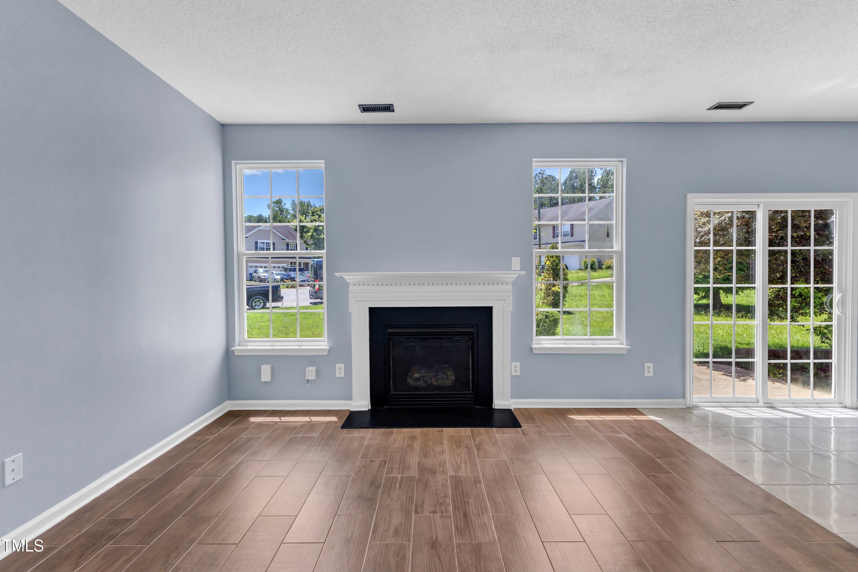 3604 Rivermist Drive Raleigh, NC 27610 - Photo 13 of 48 a view of an empty room with a fireplace and a window