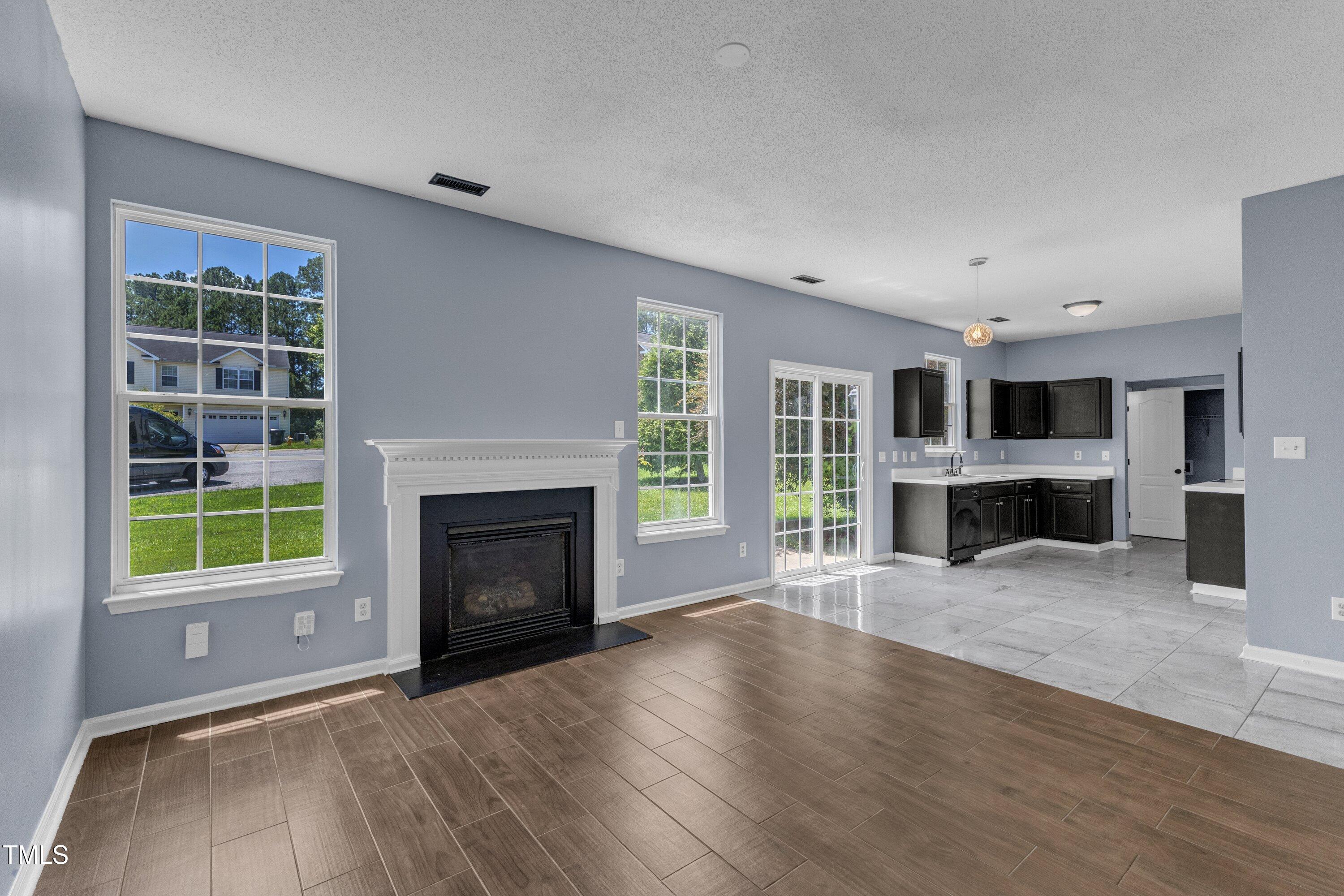 3604 Rivermist Drive Raleigh, NC 27610 - Photo 14 of 48 an empty room with furniture fireplace and windows