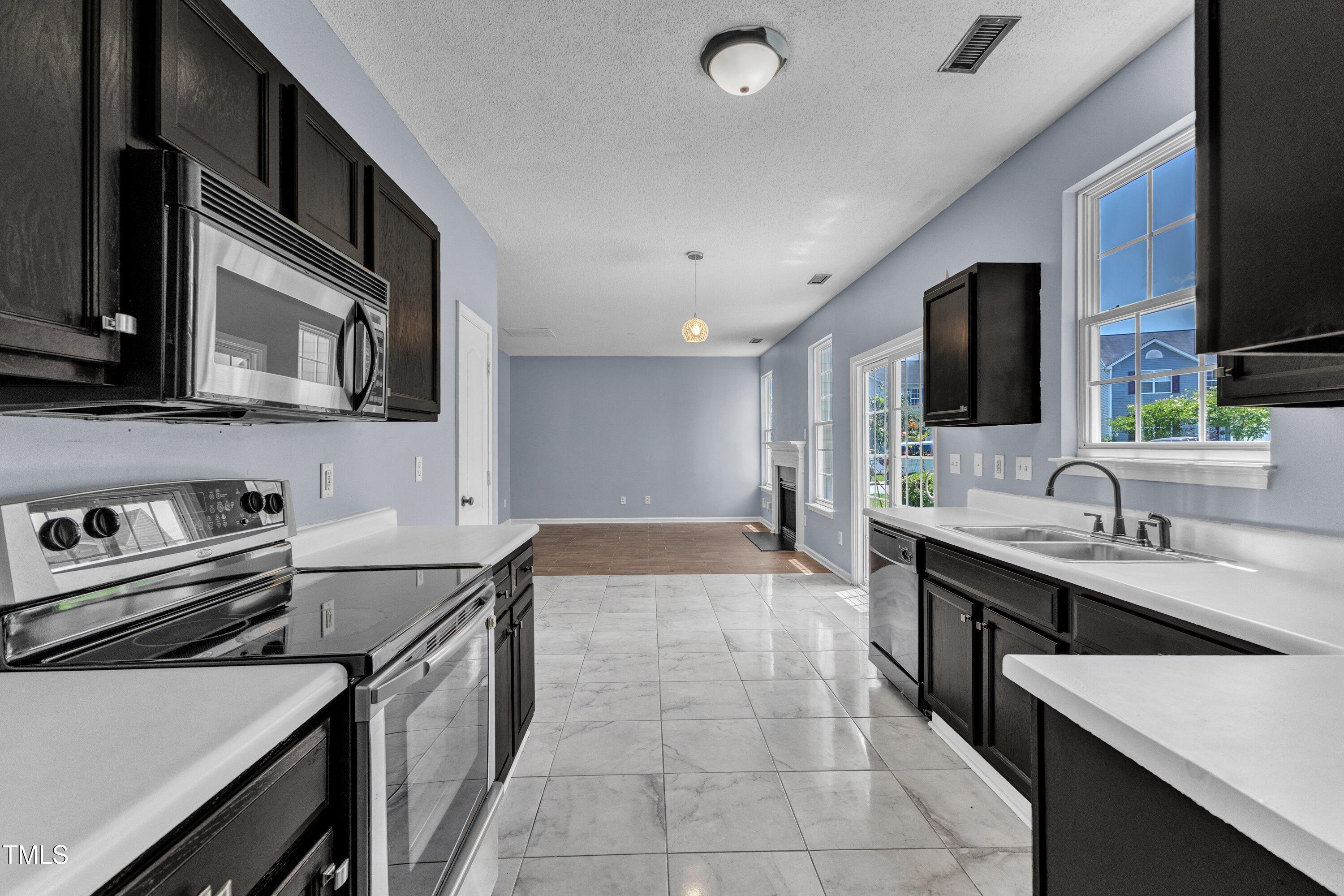 3604 Rivermist Drive Raleigh, NC 27610 - Photo 20 of 48 a kitchen with a sink stove and microwave