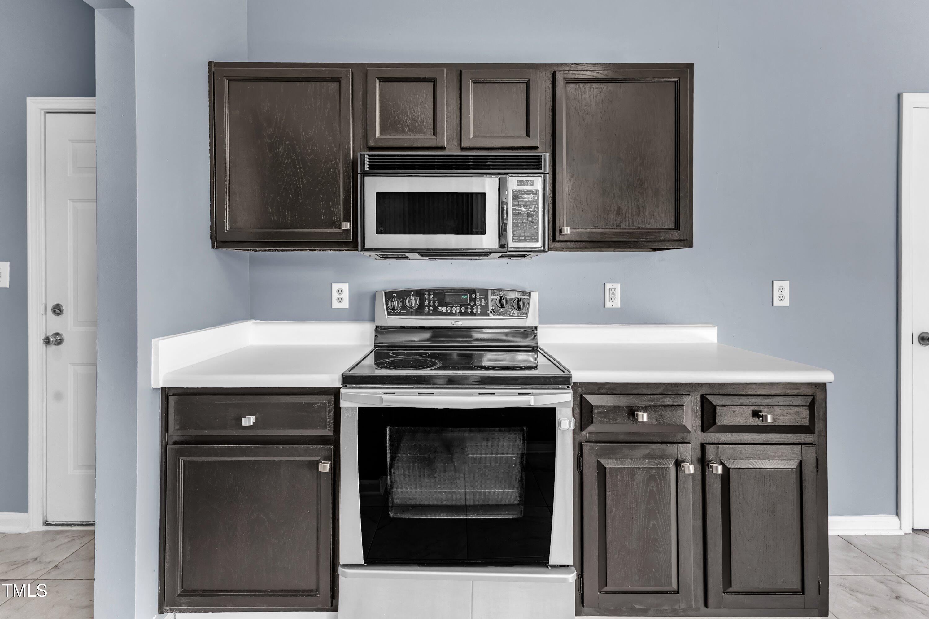 3604 Rivermist Drive Raleigh, NC 27610 - Photo 24 of 48 a kitchen with stainless steel appliances granite countertop a stove and a microwave