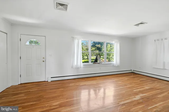 a view of a room with wooden floor and a window