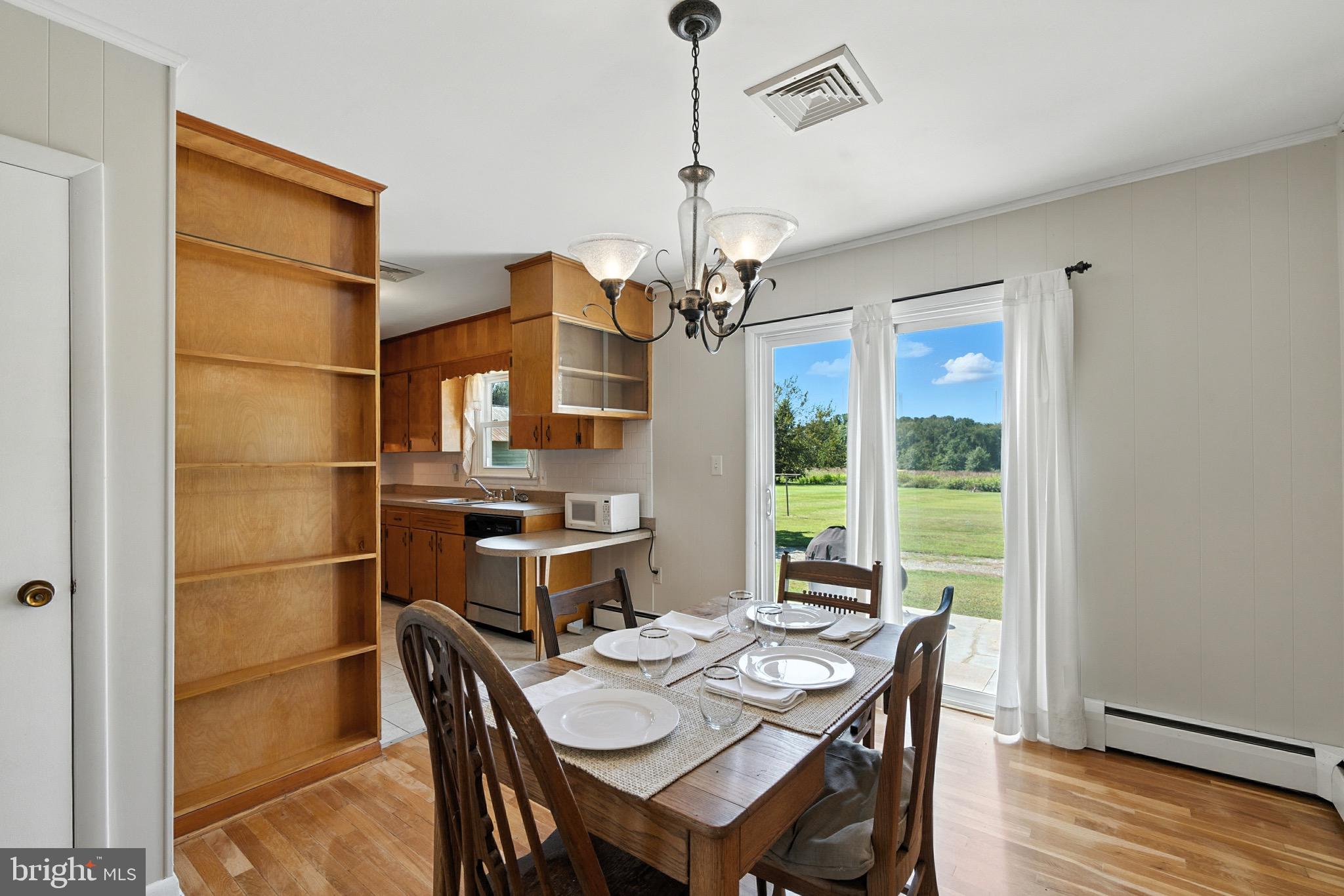 24415 Chestertown Road Chestertown, MD 21620 - Photo 7 of 29 a dining room with furniture a chandelier and wooden floor
