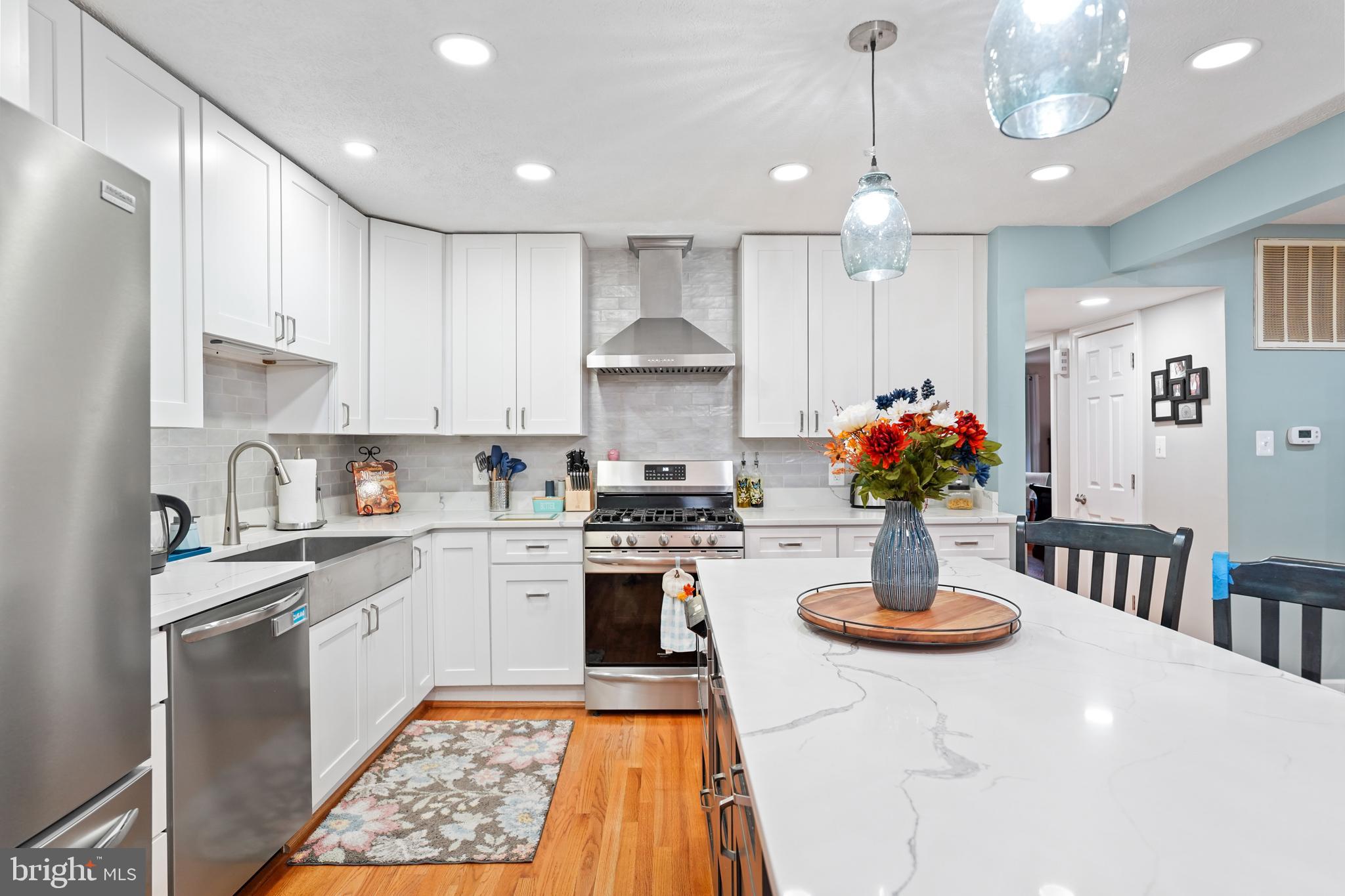 10012 Ellis Road Manassas, VA 20111 - Photo 21 of 54 a kitchen with stainless steel appliances granite countertop a stove a sink a refrigerator and white cabinets with wooden floor