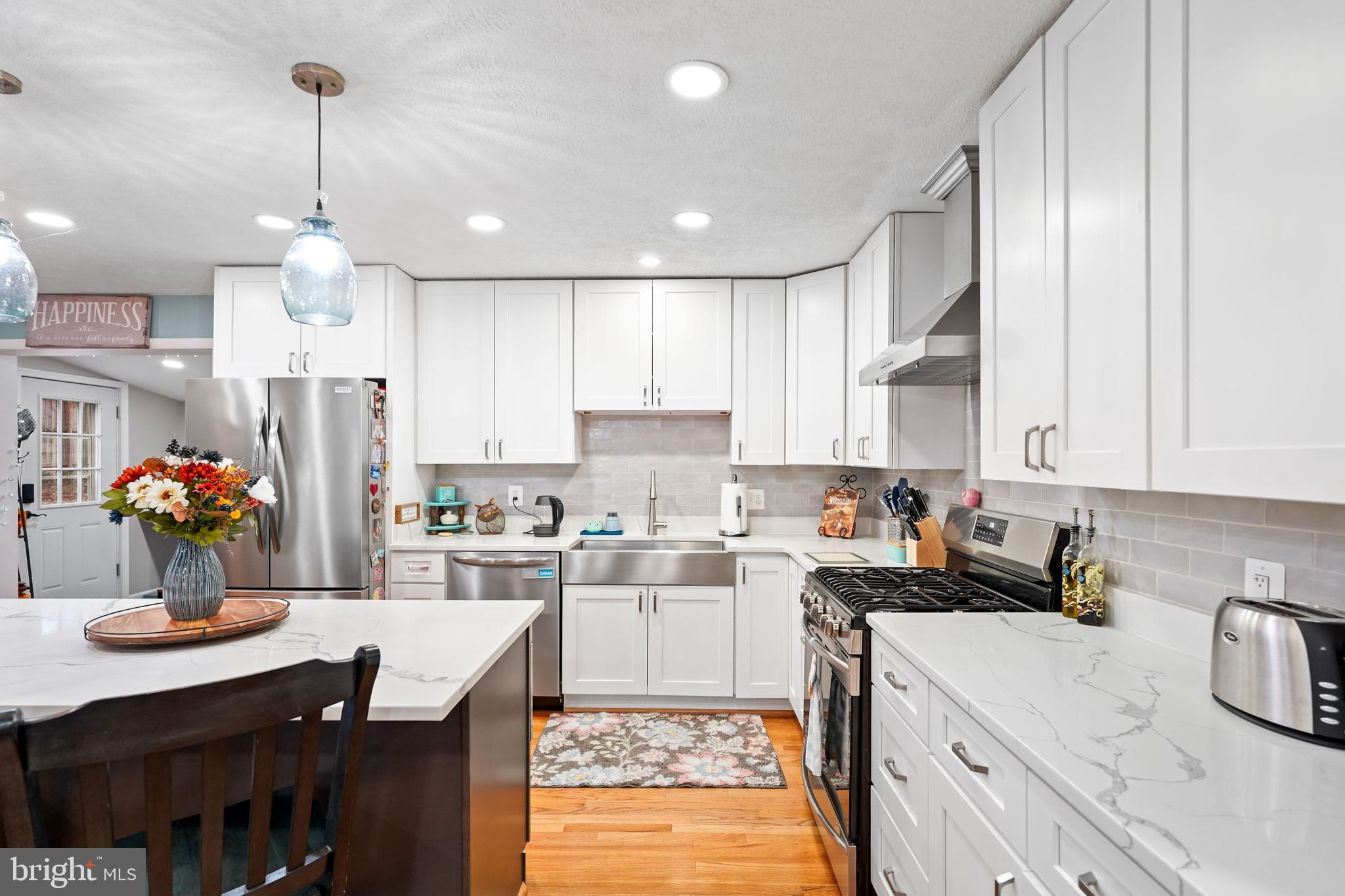 10012 Ellis Road Manassas, VA 20111 - Photo 23 of 54 a kitchen with kitchen island granite countertop a sink cabinets and refrigerator